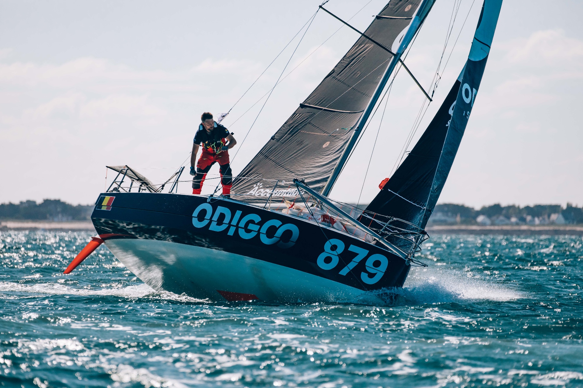 Quentin Debois manœuvrant sur le pont de son Mini 6.50 en pleine mer